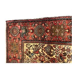 Persian ivory ground rug, the field decorated with stylised plant and bird motifs, the guarded border decorated with flower head motifs