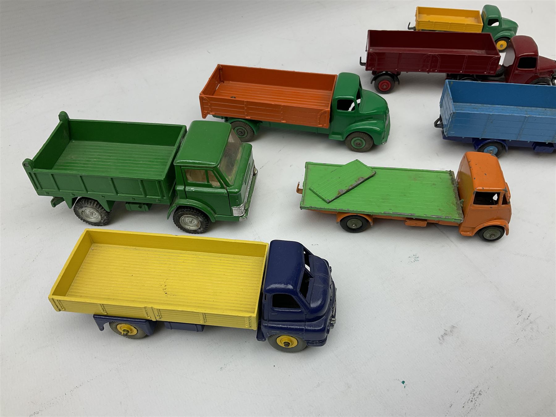 Dinky - seven unboxed and playworn/repainted die-cast commercial vehicles comprising Bedford Articulated lorry, Leyland Comet, Big Bedford, Ford 800 tipper truck, Guy flatbed and planked flatbed lorries and Dodge tipper truck (7)