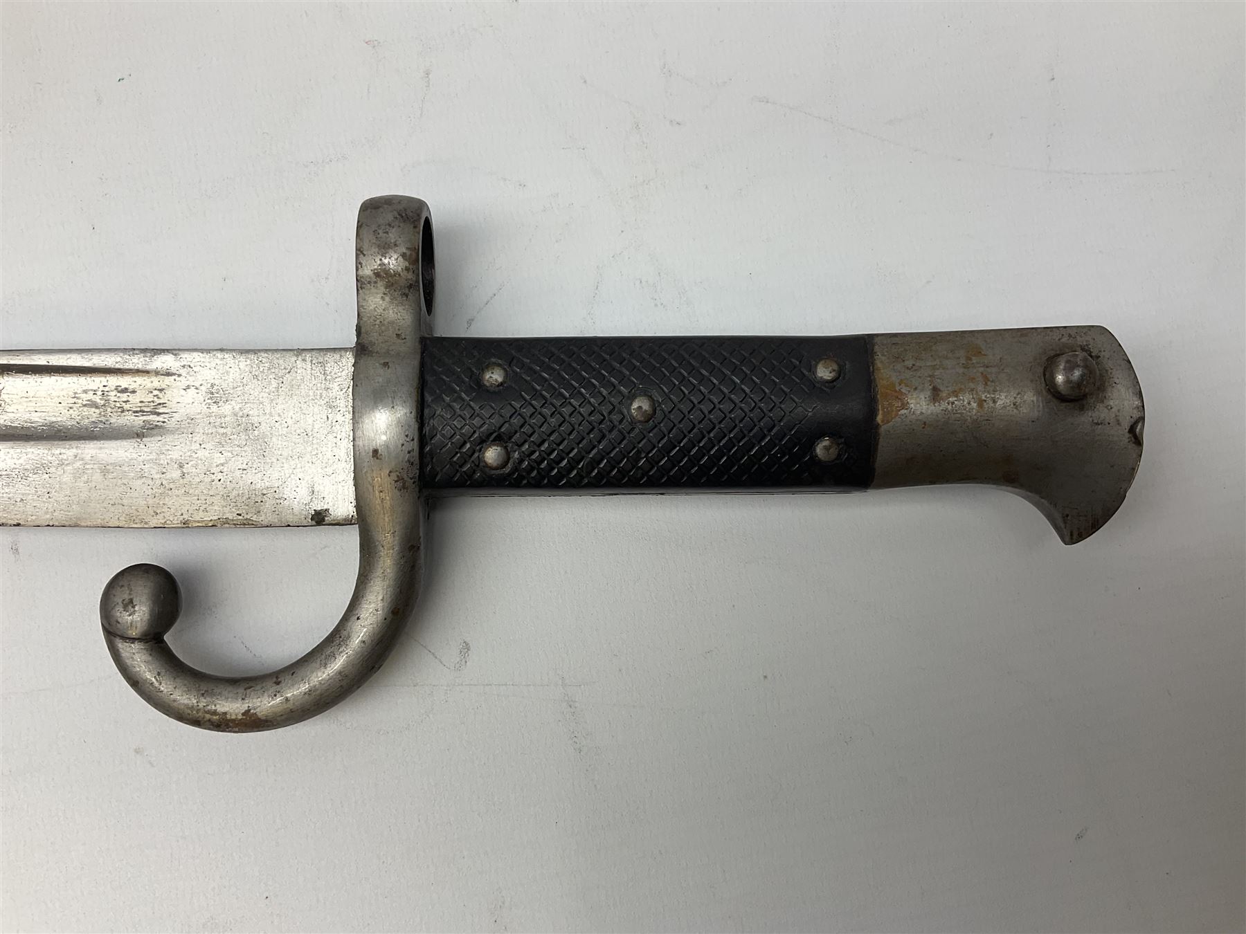 Turkish Model 1874 sword bayonet with 57.5cm curving steel fullered blade and chequered black grip, in steel mounted leather scabbard L75.5cm overall