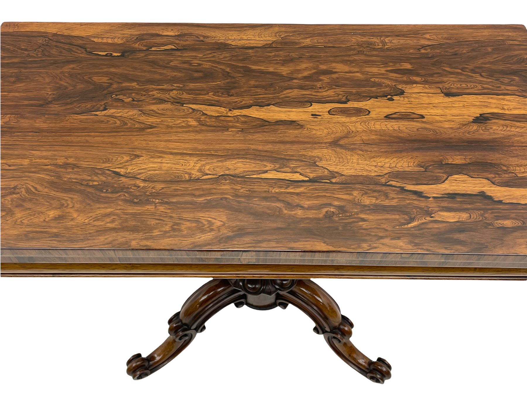 Victorian figured rosewood card table, fold-over swivel top with circular baize lining, moulded frieze with stylised flower head carving to corners, turned column with egg and dart decoration, on quadruple splayed c-scroll carved supports, with brass castors