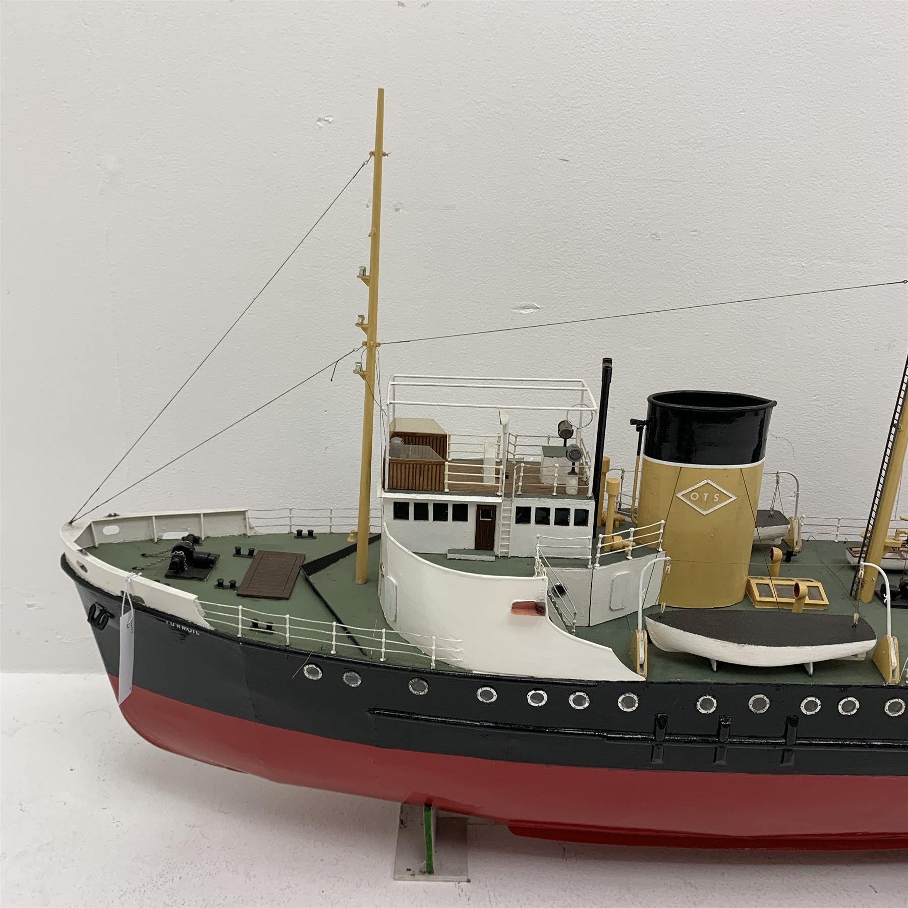 Large scale model of the motor Tug Turmoil, in OTS colours, on wooden stand, L135cm, W26cm, H66cm. Built 1945 the Turmoil was sent to the rescue of the Flying Enterprise in 1952. The Captain had refused to leave the ship, the vessel eventually sank under tow to Falmouth. Turmoil was scrapped in 1986. 
