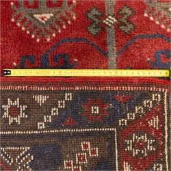 Caucasian Shirvan hand-knotted rug, red madder field with hooked lozenge medallions and stylized motifs, framed by ivory stepped spandrels and multiple geometric borders in indigo brown and ivory, with serrated palmettes and angular devices 