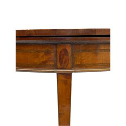 Early 19th century mahogany card table, demi-lune fold-over top with highly figured matched veneers, baize lined interior, the frieze with rosewood bands and figured oval panels, on square tapering supports with spade feet