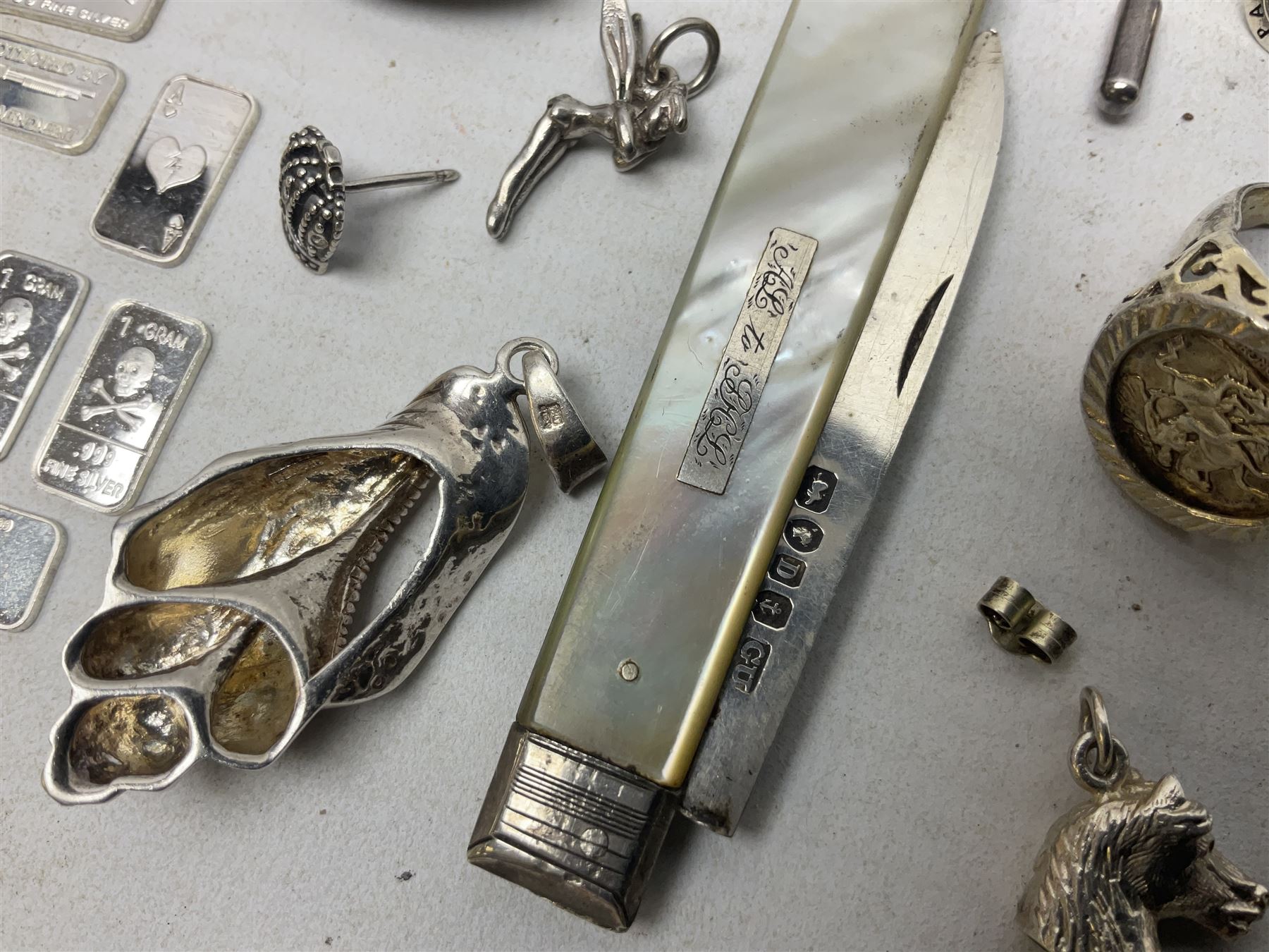 Silver mother of pearl handled fruit knife, silver jewellery including masonic pendant necklace, shell pendant, coin ring, Claddagh ring and charms etc, and a collection of ingots