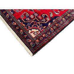 North West Persian Tafresh crimson ground rug, central indigo lozenge medallion with a geometric border and stylised flower heads and contrasting spandrels, guarded border with Bote motifs and repeating geometric shapes