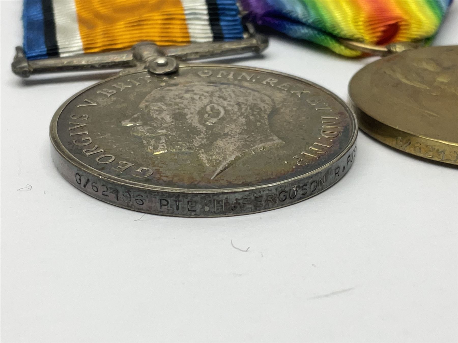 WWI pair of medals comprising British War Medal and Victory Medal awarded to G/62196 Pte. H. Ferguson R. Fus. with ribbons on wearing bar; together with bronze memorial plaque to Henry Ferguson (3)