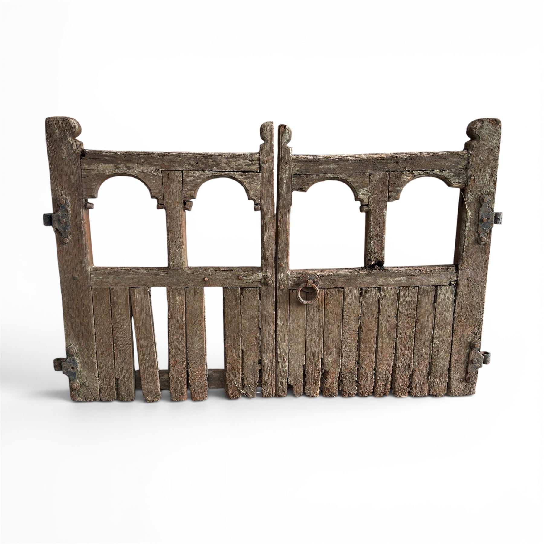 Pair of 19th century weathered wooden ecclesiastical church gates, the cresting rail over four pierced arches with slatted lower section, fitted with heavy cast iron hinges, latch and fittings
