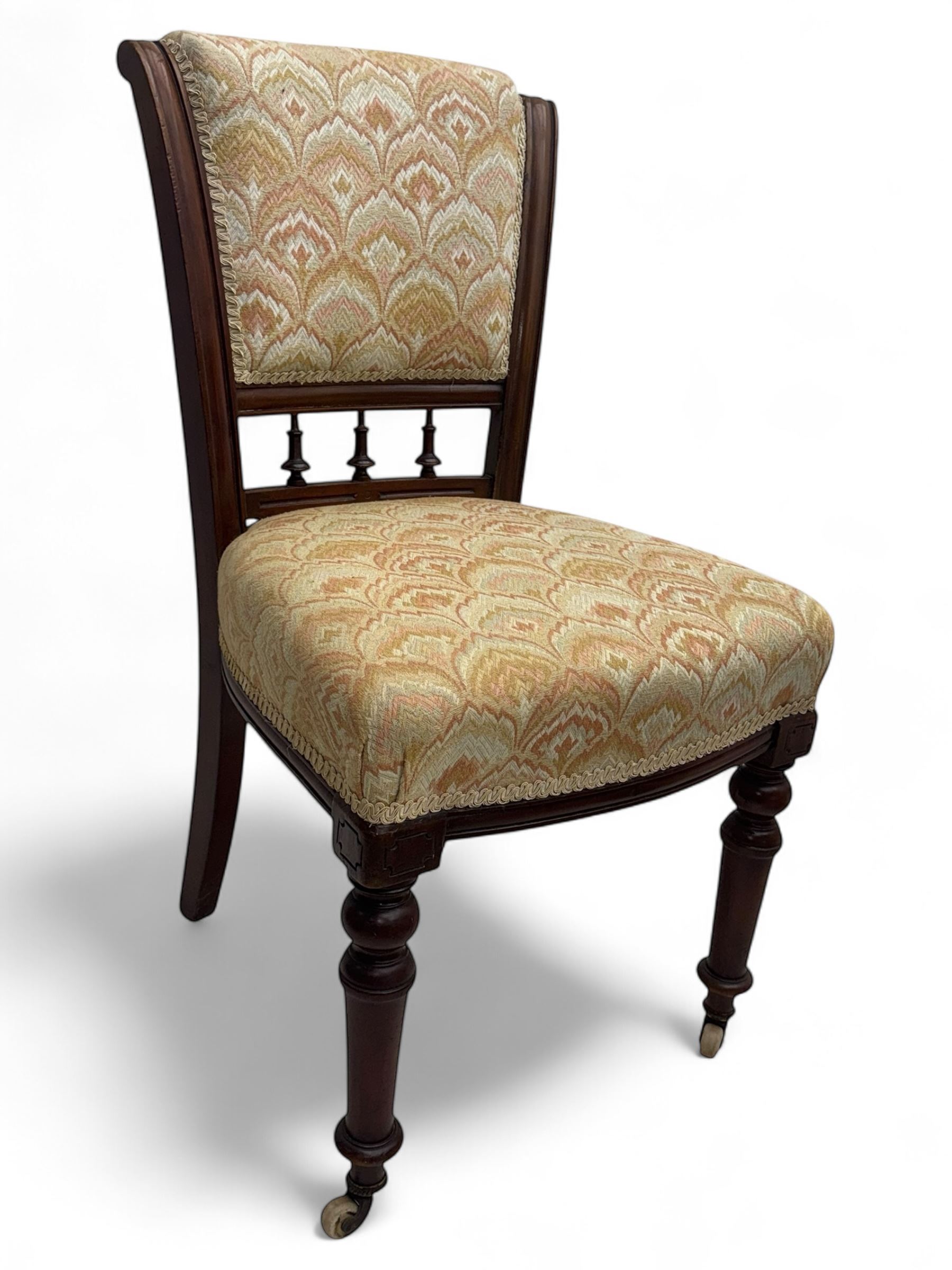 Victorian mahogany centre table, circular top above turned pedestal, terminating on three cabriole legs with scroll feet on porcelain castors, and six scroll carved upholstered dining chairs, with cushion and spindle turned backs, centre table  118x74cm, dining chairs 89x46x50cm