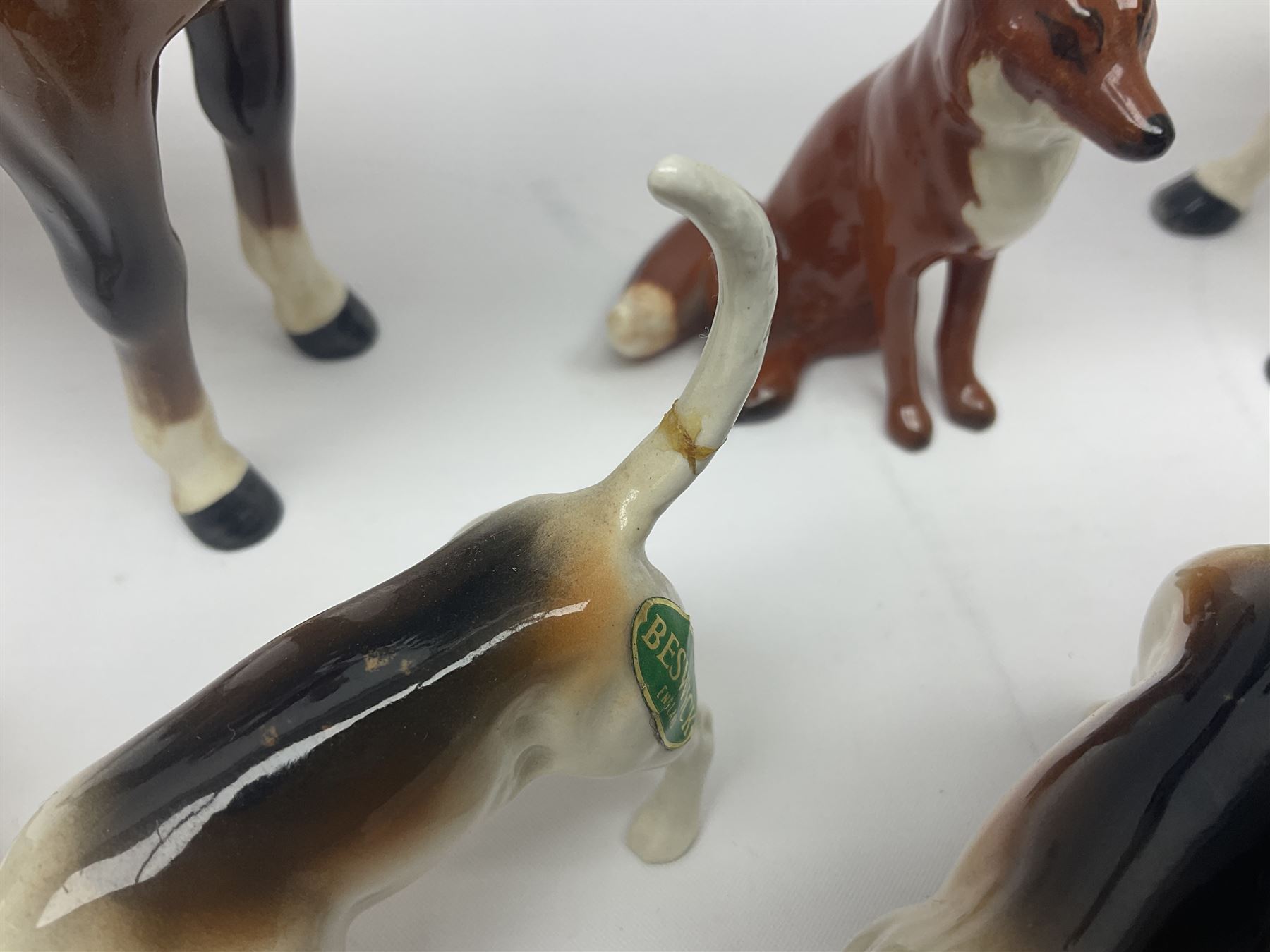 Beswick hunting group, comprising huntswoman on dappled grey horse no 1730, huntsman on bay horse no 1501, two fox figures no 1440 and 1748, and four fox hounds, all with printed marks beneath (8)