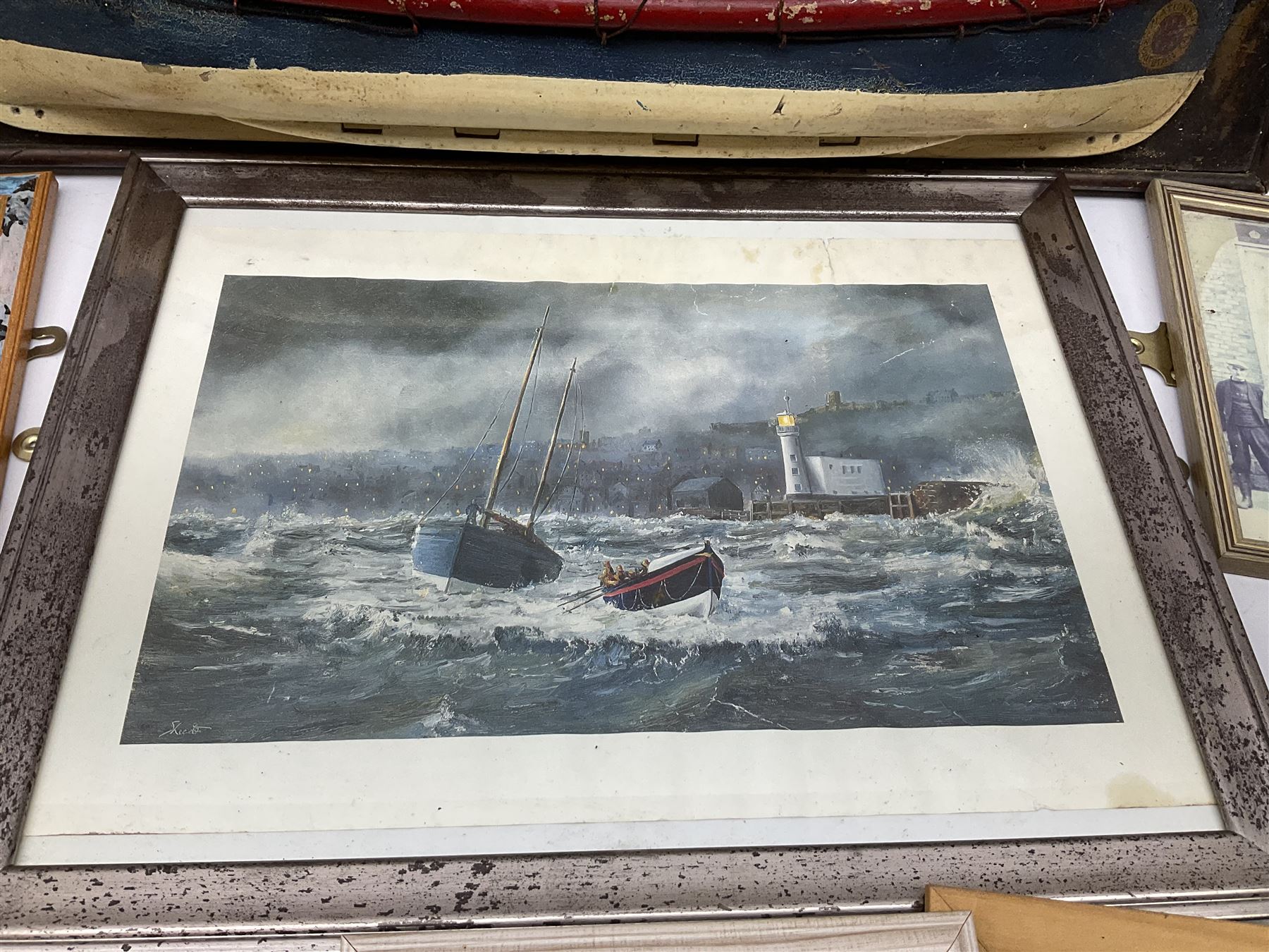 RNLI collection box in the form of a boat makers half block model, painted in the colours of a lifeboat with flag and ship motifs, H25cm, L73cm together with framed photos, postcards and prints of lifeboats and crew, including Scarborough lifeboat station