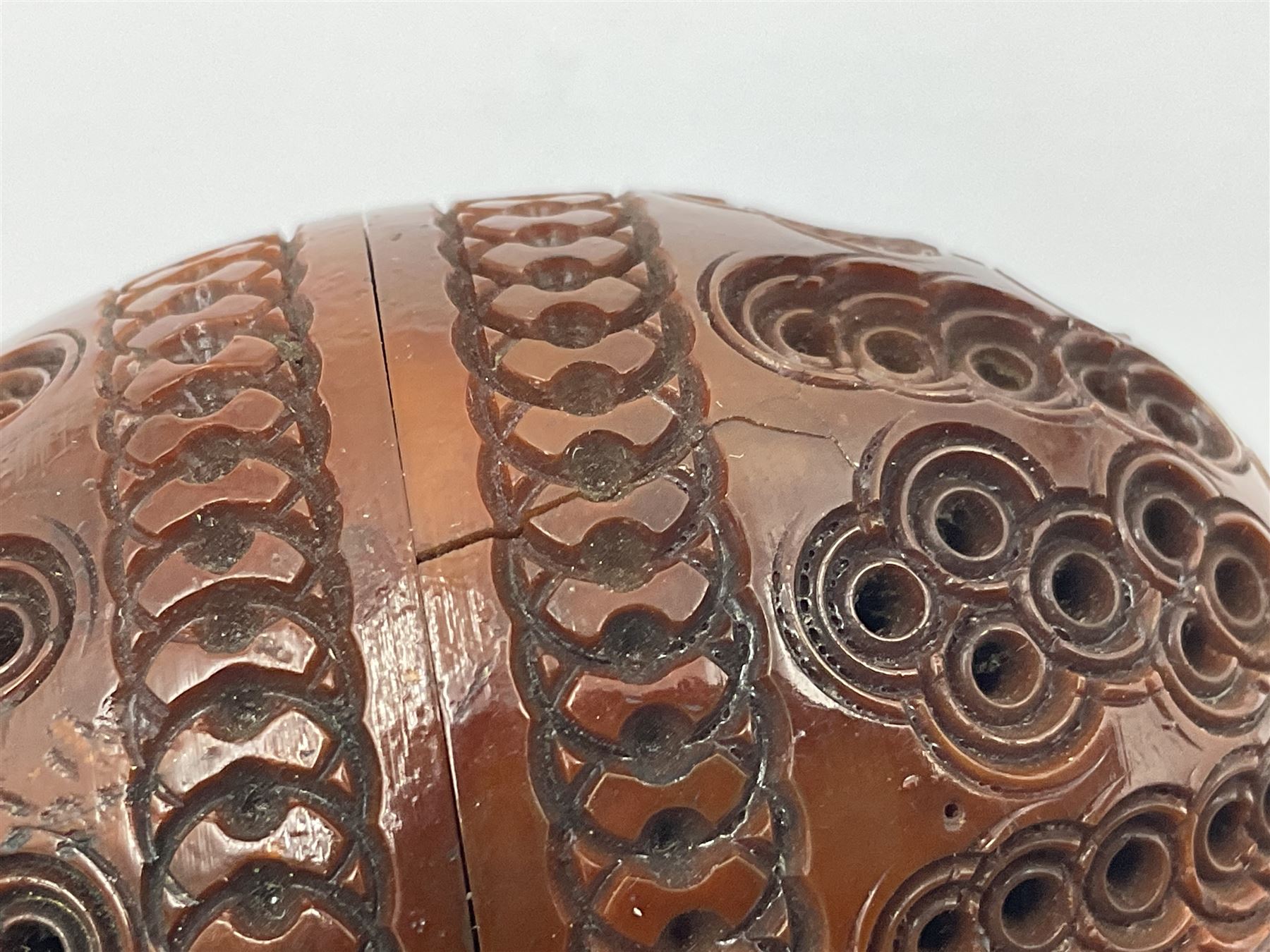 Three 19th century coquilla nut pomanders or flea catchers, two of egg shaped form and the third of barrel from with carved and pierced decoration and screw threaded join, largest H8cm