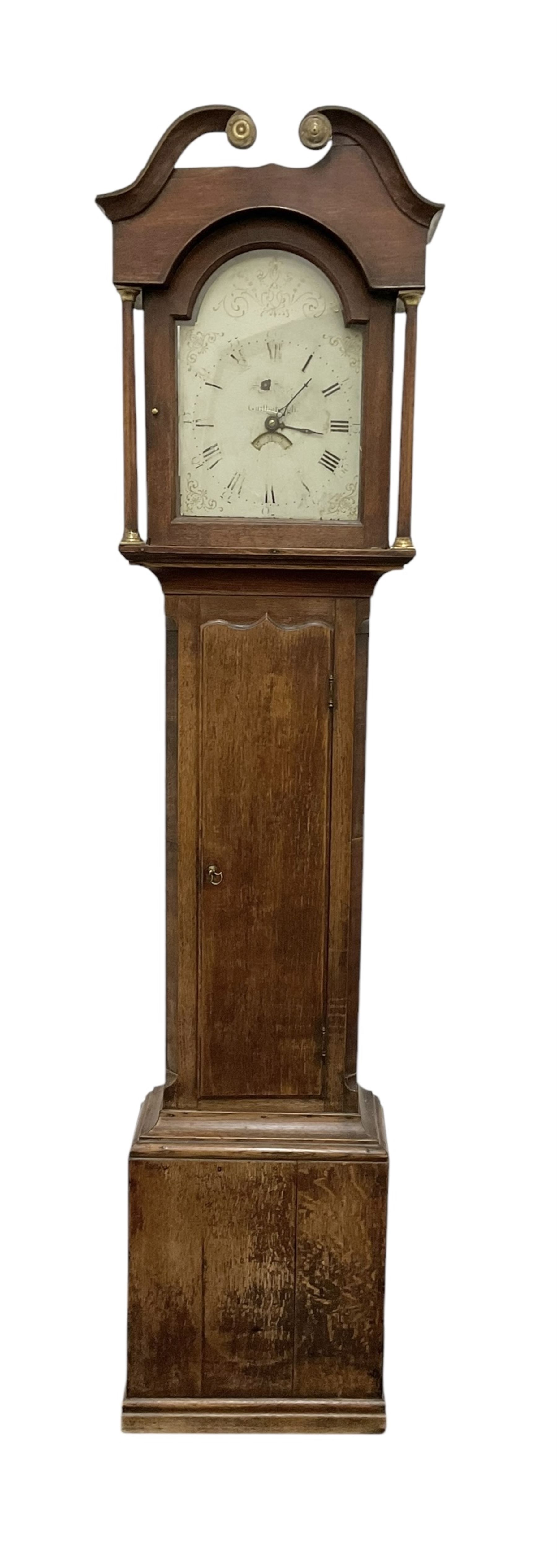 Early 19th century- 30hr oak longcase clock with a swan necked pediment and break arch hood door, trunk with canted corners and a long wavy topped door, on a rectangular plinth with applied skirting, painted dial with gold painted rococo spandrels to the corners and arch, Roman numerals and steel hands, makers name indistinct but retailed in Guisborough, with a rope driven countwheel striking movement, striking the hours on a bell. With weight and pendulum.