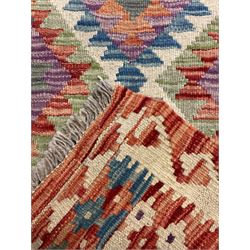 Chobi Kilim red ground and multi-coloured runner, decorated with overall geometric design, trailing lozenges within hooked border