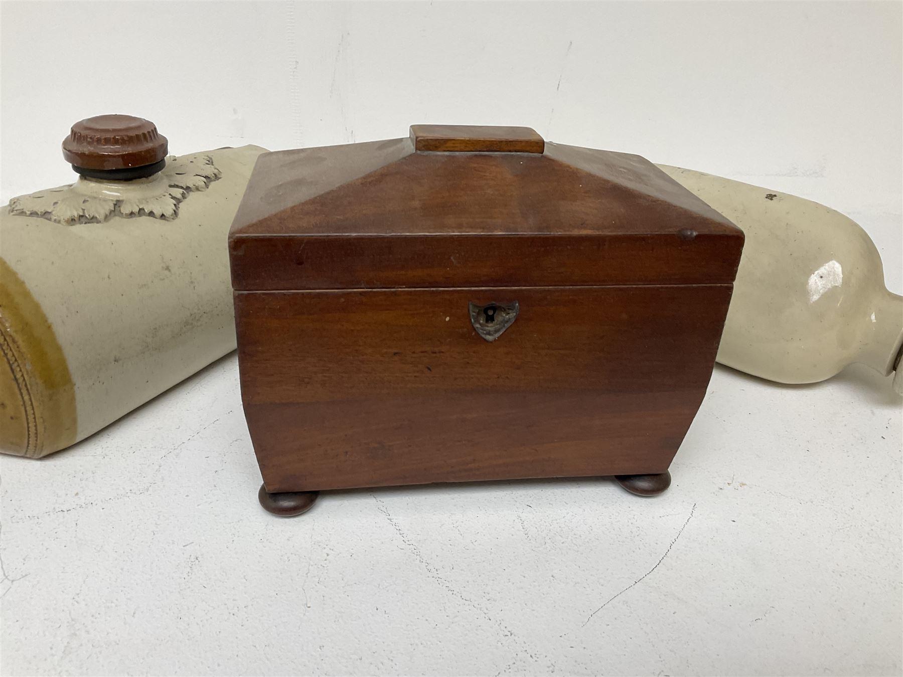 sarcophagus shaped tea caddy with bun feet, together with two stone hot water bottles, caddy H17cm 