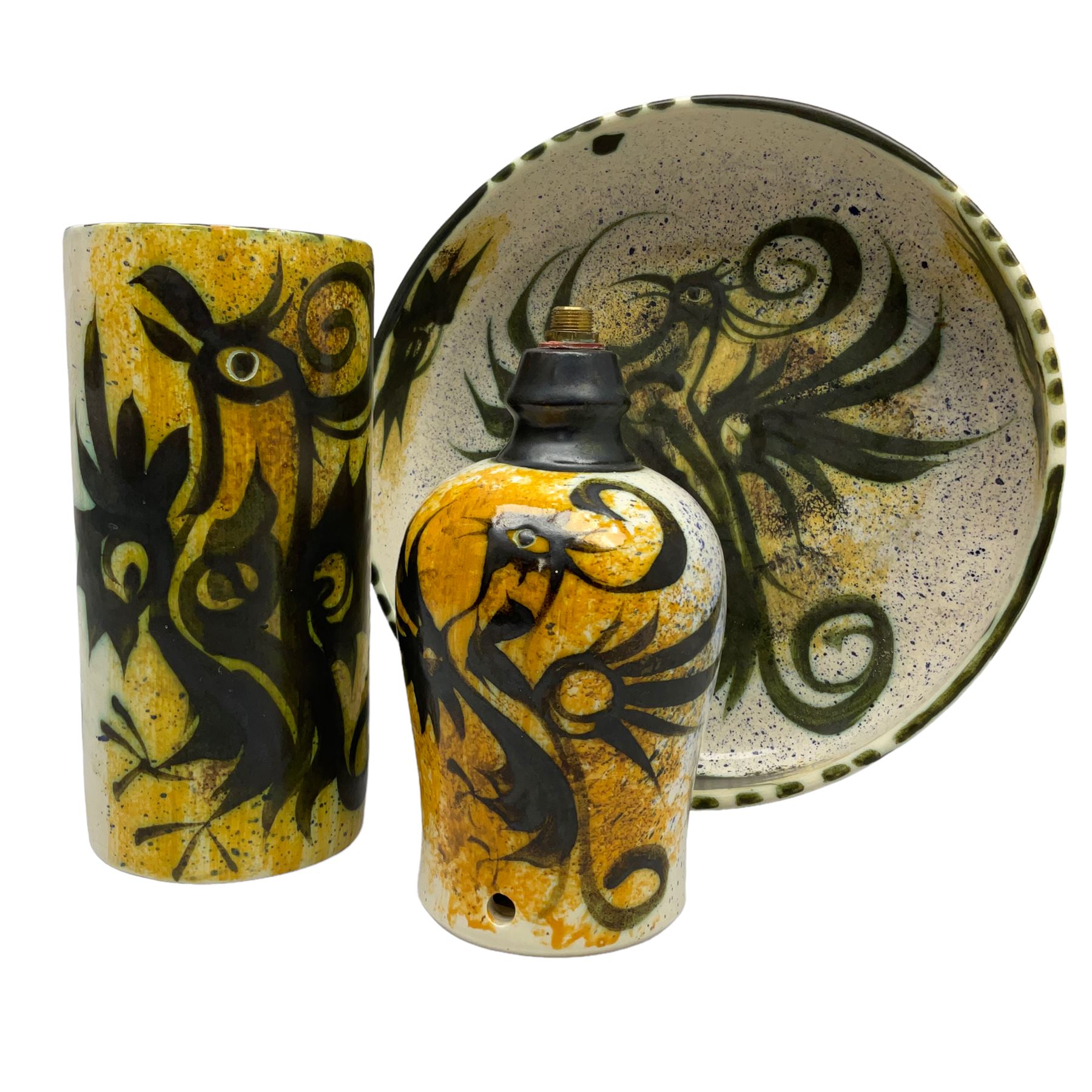 20th century Celtic Pottery, Newlyn, table lamp of tapering form, cylindrical vase and shallow bowl, all decorated with a dark stylised phoenix, modelled with wings outstretched upon sponged ochre, blue and cream ground, bowl D26cm