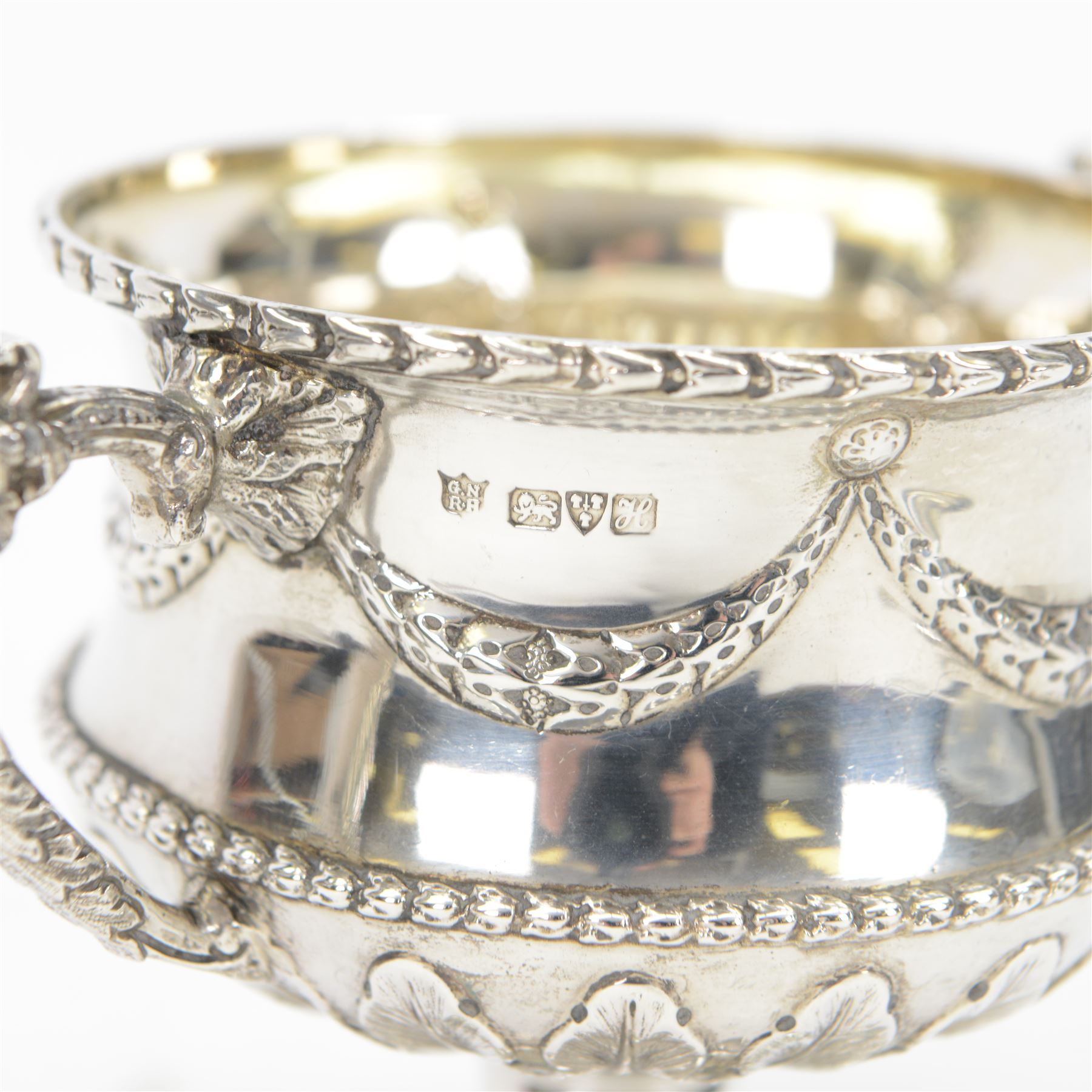 Early 20th century silver twin handled pedestal bowl and cover, the wasted body with embossed husk swag and band, above stiff leaf detailed lower section, and twin zoomorphic mask detailed handles, the slightly domed cover with conforming embossed decoration, upon a spreading circular foot, hallmarked George Nathan & Ridley Hayes, Chester 1908, H15cm
