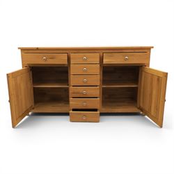 Solid oak sideboard fitted with drawers and cupboards, central bank of six drawers, metal pulls 