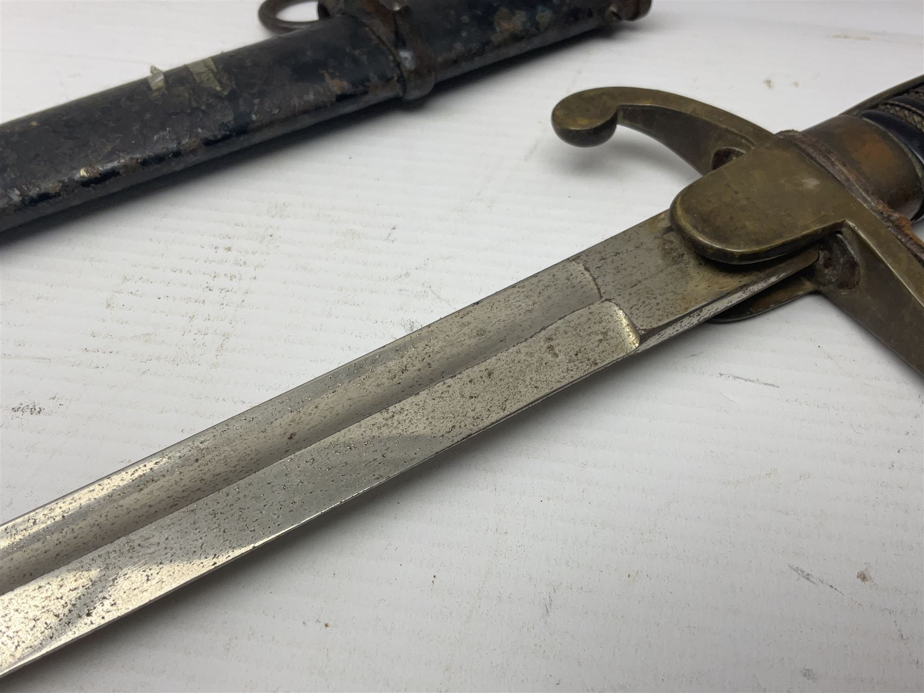 Prussian artillery officer's sword, with 80cm slightly curving fullered  blade, brass hilt with D-shaped langets, curving knucklebow, wire-bound black grip and leather finger loop; in black painted steel scabbard with single suspension loop
