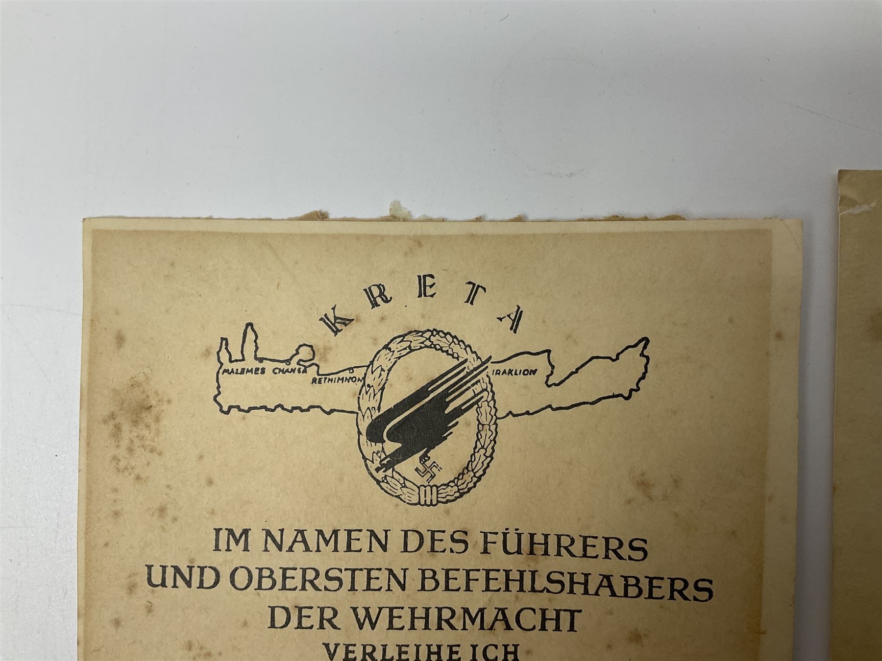 Three German documents dated 1942 - Gold Cross award to Major Ludwig Osterkampf; and Crete wound certificate and cuff title certificate awarded to Feldwebel Alfred Glaise; all unframed (3)