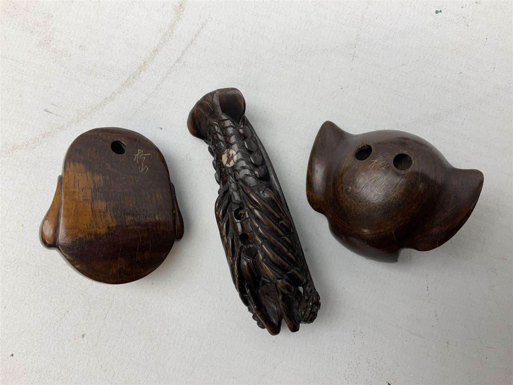 Group of ten Japanese netsukes, comprising eight carved wooden examples, and two ivorine examples, of various form, examples modelled as pigs, owl, mouse with tortoise upon its back, birds, rabbit, etc. 