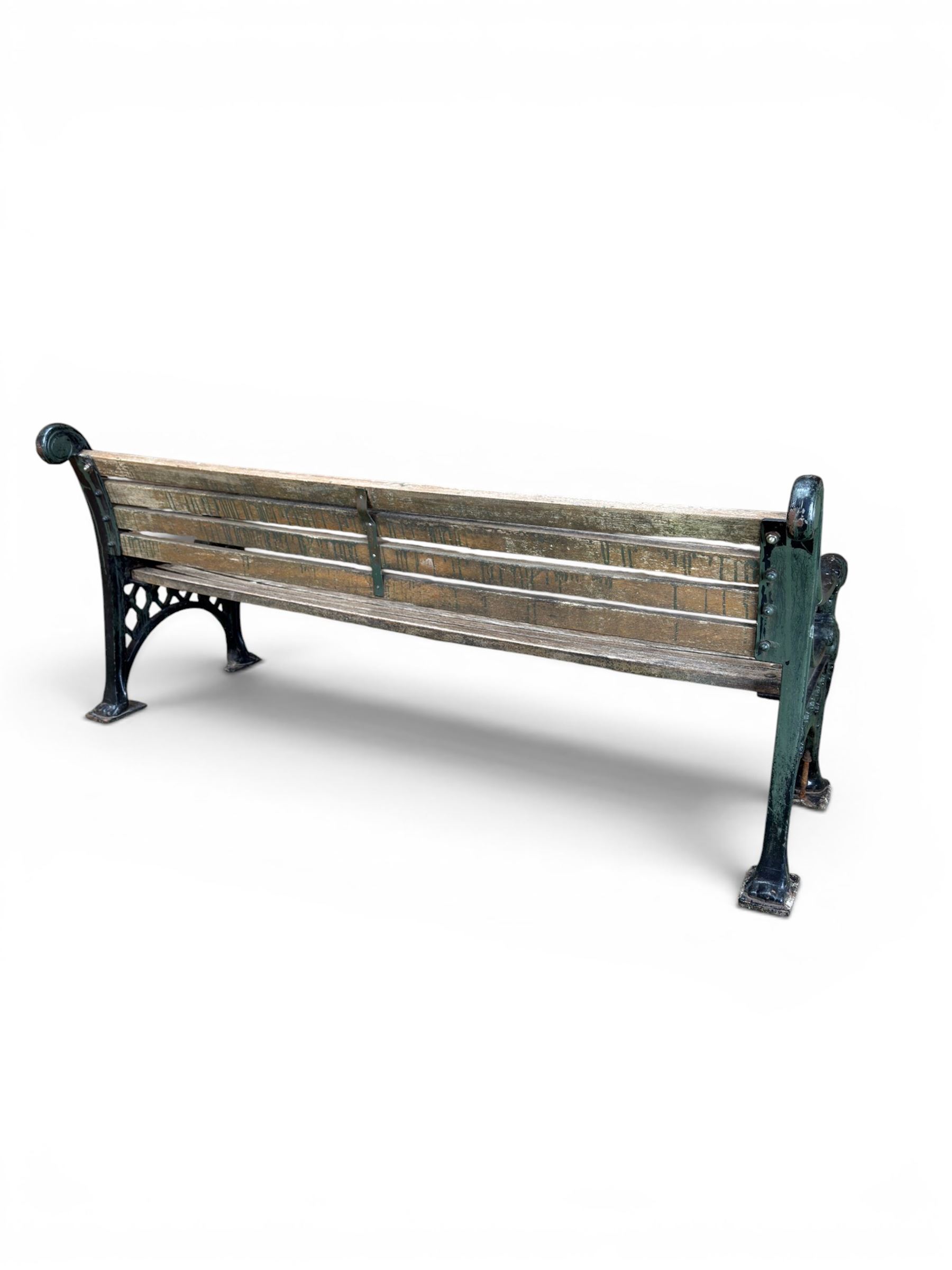 Neoclassical design cast iron and oak slatted garden bench, the twin end supports in the form of a Sphinx with acanthus carved knees and large paw feet, the pierced lattice bracket with Yorkshire rose motifs