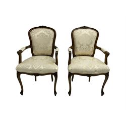 Pair Louis XVI design walnut framed salon armchairs, cresting rail with applied garland decoration, back and seat upholstered in foliate patterned ivory damask fabric, raised on cabriole supports with shell moulded knees and scrolled acanthus leaf feet 