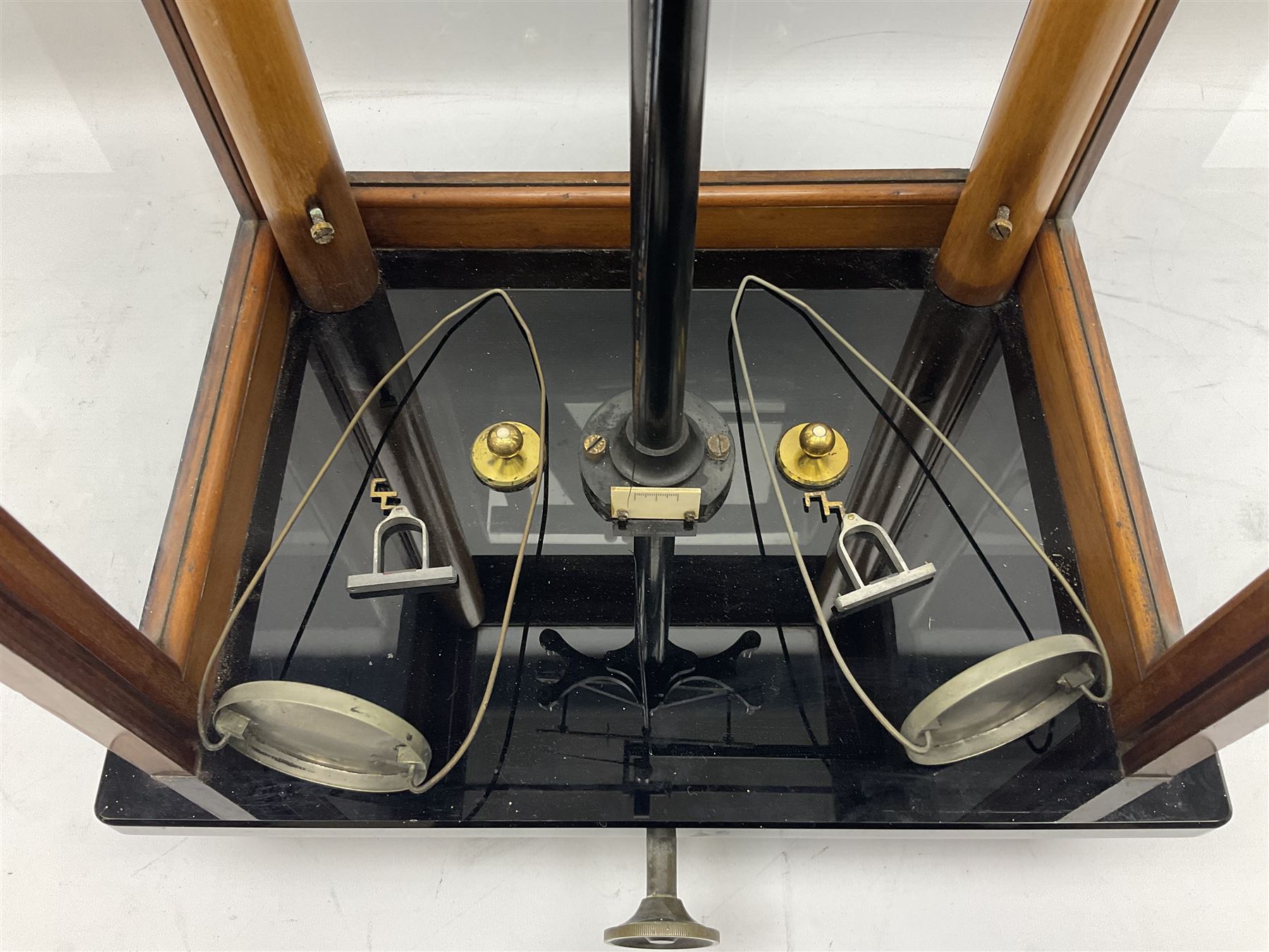 Set of laboratory balance scales by Reynolds & Branson of Leeds in fully glazed mahogany case with rise-and-fall front door, black vitrolite base with brass feet and hand cranked action L40cm H51.5cm D30cm; and bakelite cased set of brass weights