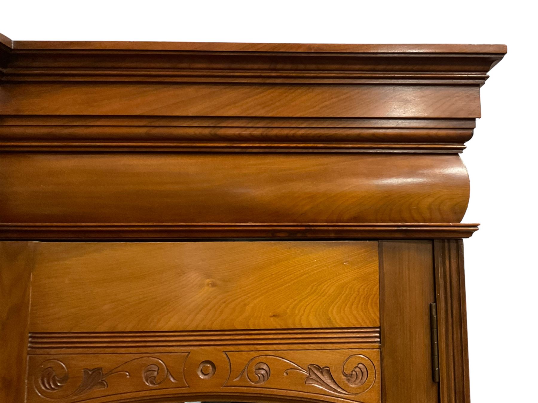Edwardian walnut combination breakfront triple wardrobe, projecting cornice over cushioned and fluted frieze, central fielded panelled cupboard carved with foliate decoration above two short and three long drawers, flanked by two bevelled mirror doors enclosing hanging hooks with single drawers to base, retailed by J Tonks & Sons, Scarborough