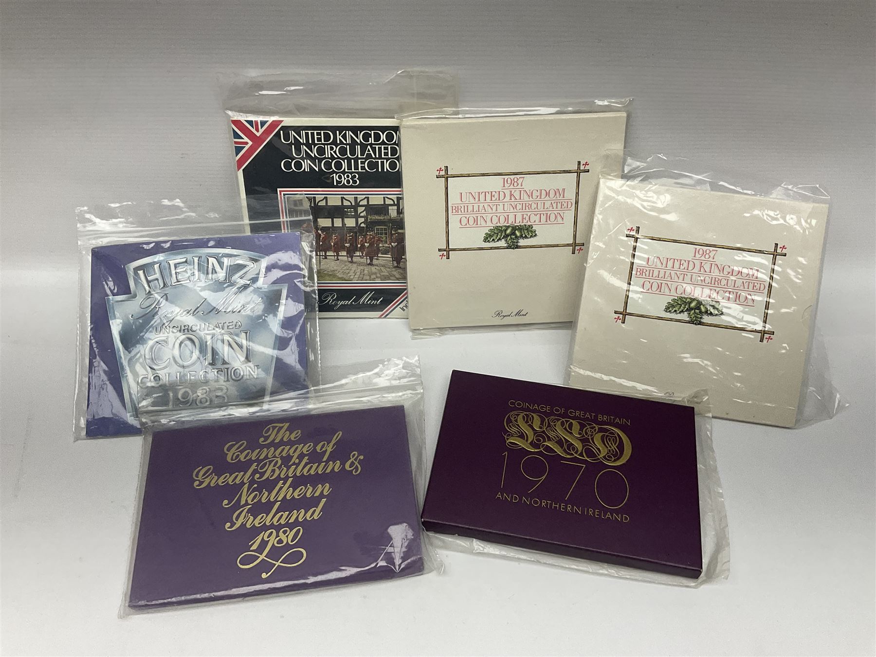 The Royal Mint United Kingdom 1983 proof coin collection in blue folder with certificate, 1983 uncirculated coin collection, two 1987 brilliant uncirculated coin collections, commemorative crowns etc