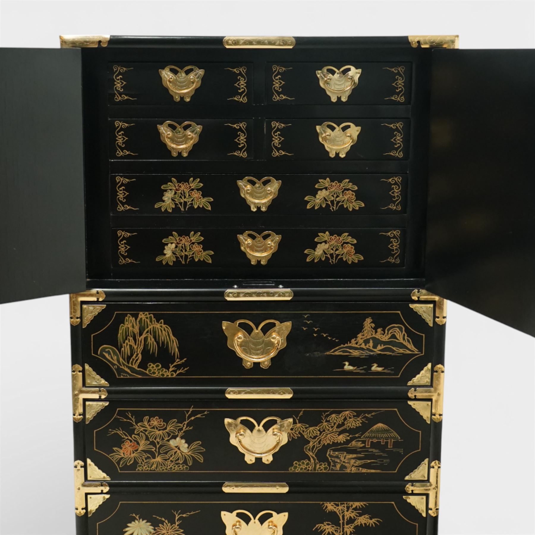Japanese Shibayama style black lacquered curio chest, cupboard doors enclosing four short over two long fitted drawers, decorated in gilt with birds, flowers and landscape scenes, raised on gilt mounted bracket feet