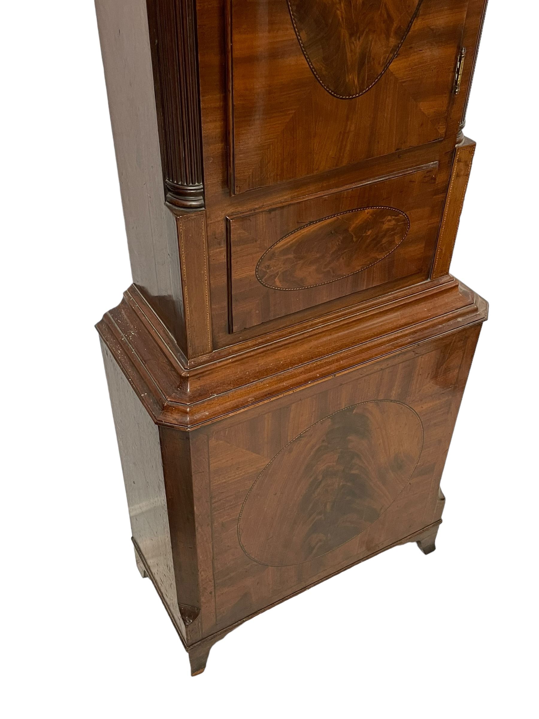 John Morgan of Aberystwyth - fine George IV mahogany 8-day longcase clock c1820, with a raised swan necked pediment, ball and eagle finial and deep inlaid frieze beneath, square hood door with a glazed circular wooden bezel and canted corners, long trunk with reeded quarter columns and a wavy topped door, rectangular plinth on bracket feet, circular painted dial with Roman numerals, minute track, makers name, and brass stamped hands, rack striking four pillar movement with a recoil anchor escapement, striking the hours on a bell. With weights and pendulum. 
John Morgan is recorded as working in Aberystwyth 1816-35. 