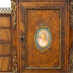 Late 19th-century Louis XV revival gilt bronze mounted and walnut Bonheur-de-Jour, rectangular-shaped serpentine form, with gilt bronze beading, frieze with two blind drawers and gilt bronze handles, centre drawer with large central serves style porcelain plaque, the elevated section with brass gallery above panelled cupboard doors also with serves style porcelain plaques and gilt bronze mounts, interior with single shelf, central section with four drawers each with gilt bronze handles, raised on slender cabriole legs fitted with gilt bronze rococo style masks and sabots