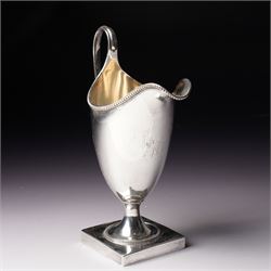 George III silver helmet shape cream jug engraved with a monogram with loop handle on squa...