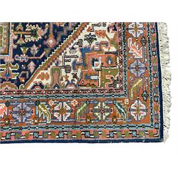 Persian Heriz indigo and rust ground rug, central geometric star medallion decorated with stylised foliate motifs, the border decorated with stylised flower heads
