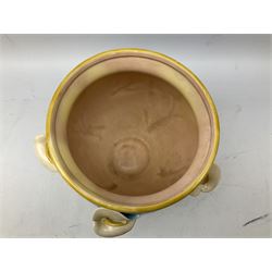 George Jones style majolica jardiniere of globular form, supported on four feet formed from modelled lily leaves growing up the side of the pot, with swallows flying amongst the white lily flowers, all set against a blue ground, with a pink interior, H27cm