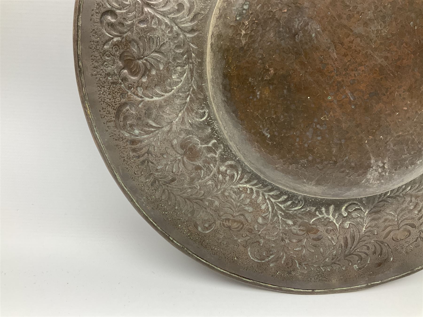 Arts and Crafts Keswick School of Industrial Arts copper charger, decorated with planished centre and repousse scrolling foliate tendrils to rim, D44cm