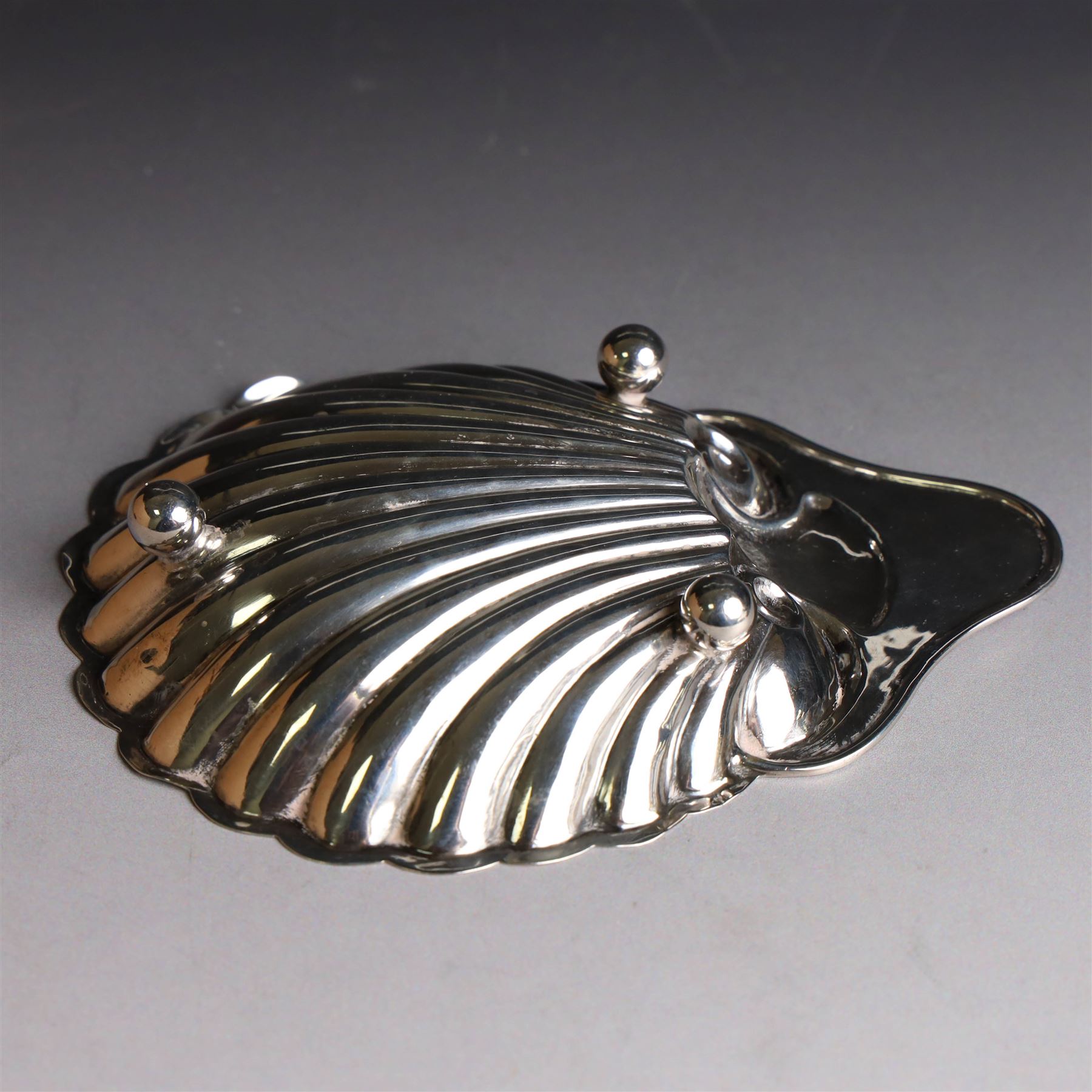 Edwardian silver clam shell butter dish, upon three bun feet, hallmarked James Deakin & Sons, Sheffield 1910