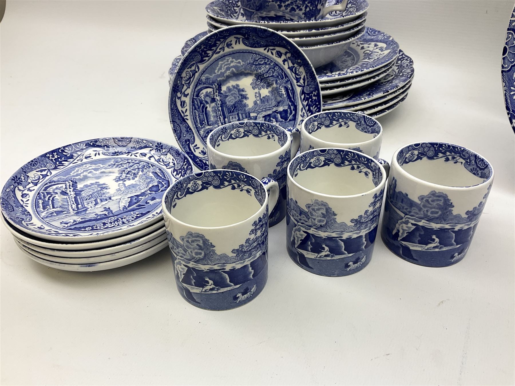 Spode blue and white Italian pattern dinner and tea wares, comprising five dinner plates, four side plates, seventeen side plates, four bowls, ten tea cups and twenty one saucers, five coffee cans and six saucers, and a flan dish, with blue and black printed marks beneath 
