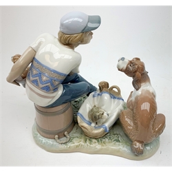 A Lladro figurine, 'This one's mine' Model 5376, H19cm, together with three further Lladro figurines, 'Joy in a Basket' Model 5595, and Sweet Dreams Model 1535, and an example modelled as a boy in hat and scarf, with umbrella and dog by side. 