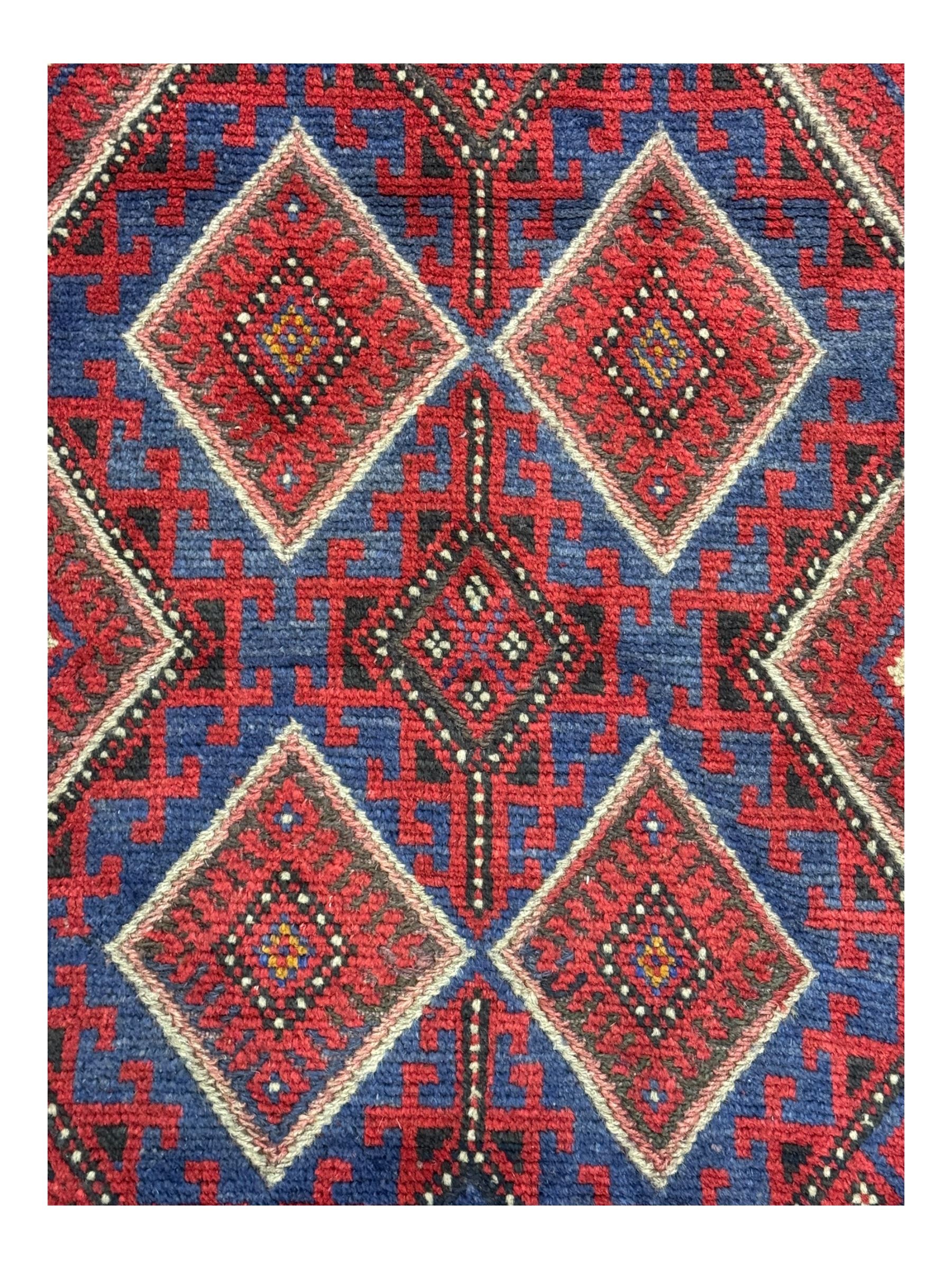 Pashtun Meshwani ground runner, central field decorated with rows of multicoloured diamond medallions, surrounded by geometric motifs, wide red and blue striped border with additional guard bands