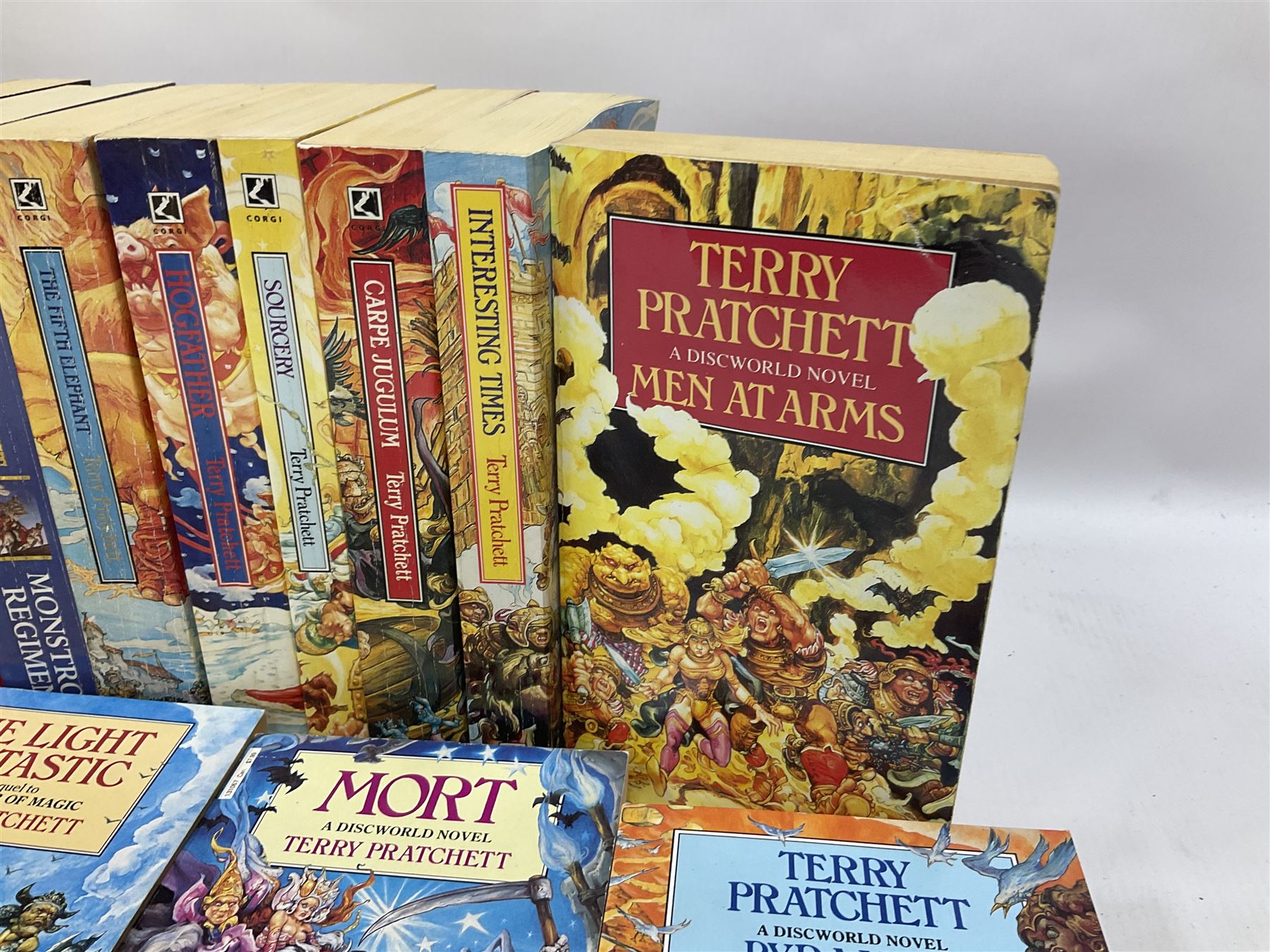 Collection of books by Terry Pratchett, of mostly Discworld interest, to include hardback edition of Going Postal, and further books such as Men at Arms, Sourcery, Small Gods etc 