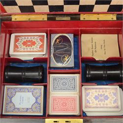 19th century walnut and brass bound games compendium box, painted to enhance the grain, of rectangular form, the hinged opening cover with rounded sides, central brass cartouche with engraved lion crest, and brass riveted straps, opening to reveal a red leather and blue silk lined compartmented interior, with fold-down games board, and lift-out tray containing playing cards, ebony turned dice towers, white and red stained bone draughts, and chess pieces, ivory dice, and ivory and ebony whist markers, and brass bezique board, cribbage board and markers, H15cm W32cm D24cm
This lot has been registered for sale under Section 10 of the APHA Ivory Act