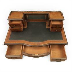 Maple & Co - Edwardian mahogany inlaid writing desk, the superstructure with pierced brass gallery, above an inset mirror and two short drawers, inset leather writing surface, bow fronted with crossbanded drawers and brass swan neck handles, square tapering supports terminating in castors 