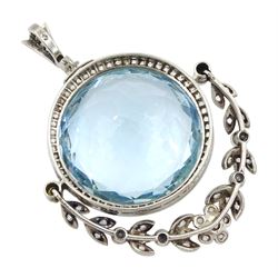 Early 20th century silver and platinum aquamarine, diamond and pearl pendant, the round cut aquamarine of approx 27.00 carat, with milgrain set diamond surround and hinged diamond and pearl set foliate drop, circa 1910-1920, in fitted box, retailed by Diss & Sons, Dewsbury