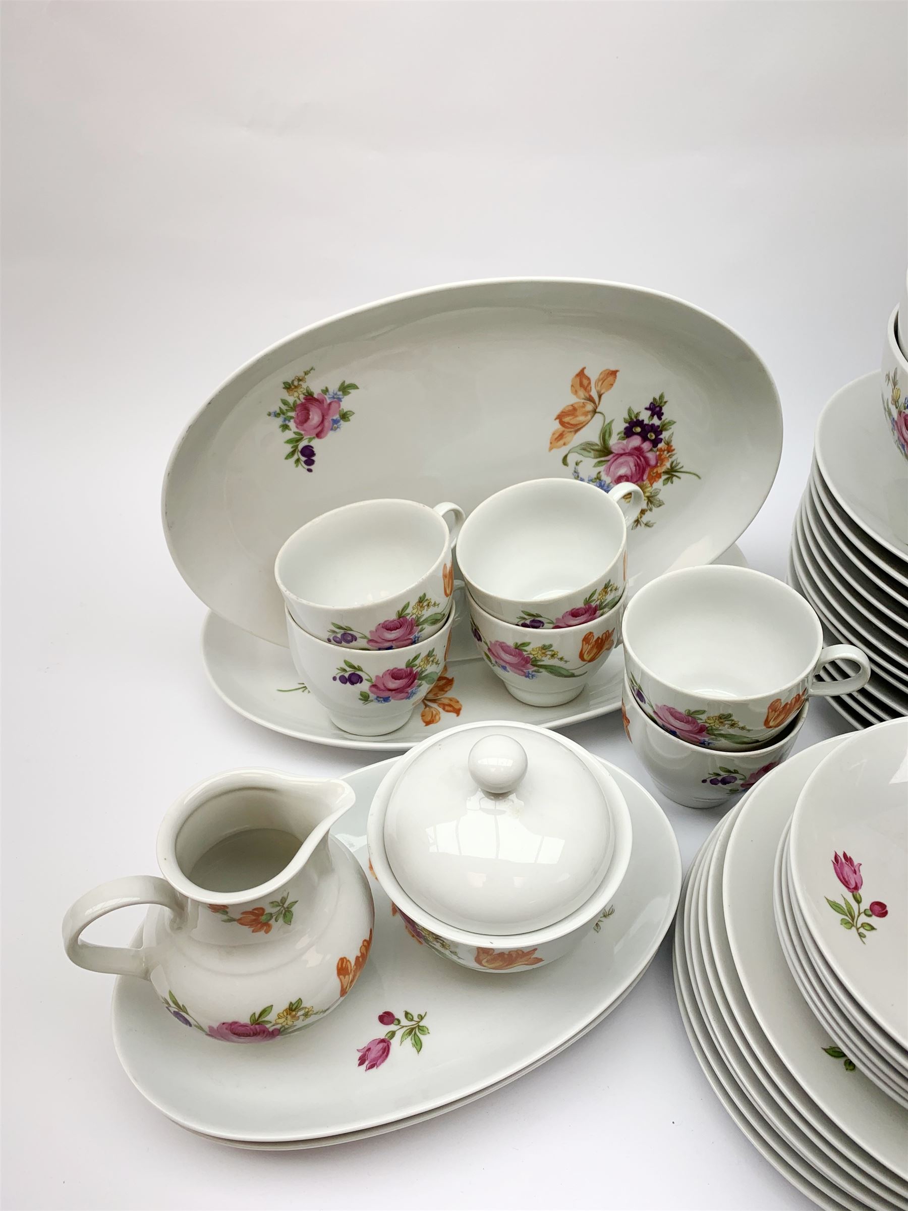 JLmenau German tea and dinner wares, comprising twelve dinner plates, seventeen side plates, twelve bowls, four large serving bowls, pair of oval serving platters, pair of smaller examples, two coffee pots, eleven teacups, twelve saucers, two milk jugs, two larger jugs, and two lidded sucriers. 