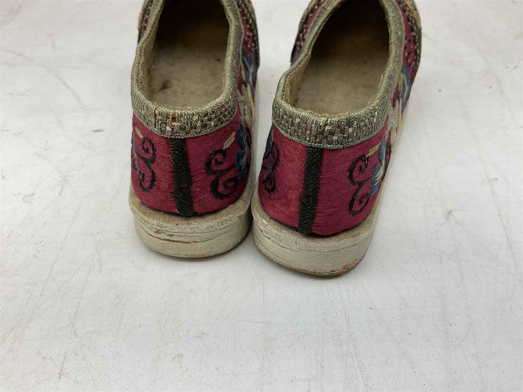 French silver plated wine taster of typical form, stamped, together with a silver plated napkin ring, and an 'Alpaca Silver' pill box with mother of pearl detailed cover, (3) together with Two pairs of late 19th/early 20th century Chinese Lotus shoes for binding feet, the first with purple silk heavily embroidered with ornate floral motifs, L10cm the second larger fuschia and black pair with thicker sole embroidered with flowers, L14cm