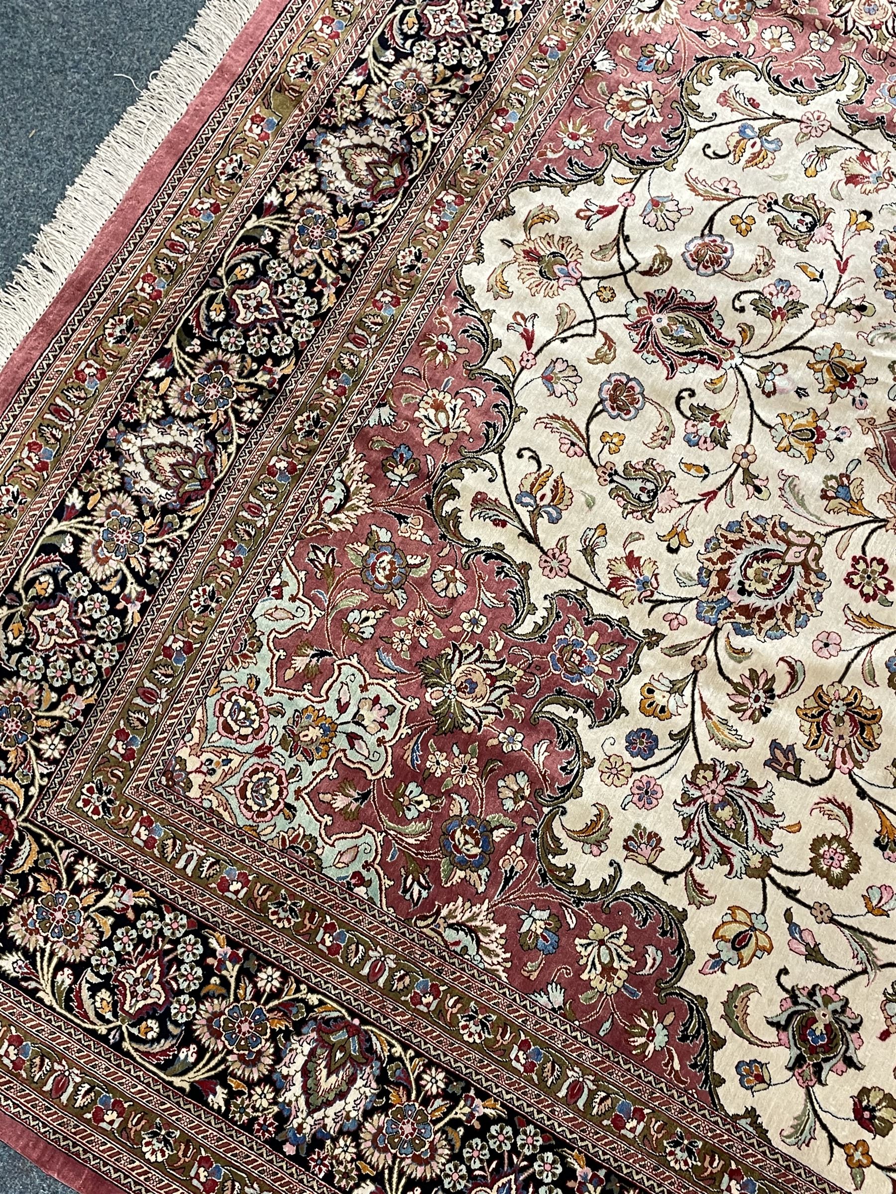 Finely knotted Persian Qom silk rug, overall pink ground with ivory field, the field with central cusped medallion profusely decorated with interlacing foliate and stylised flower heads, multiple band boarder, the main band decorated with a series of stylised motifs and trailing foliage, the outer guard with signature panel 