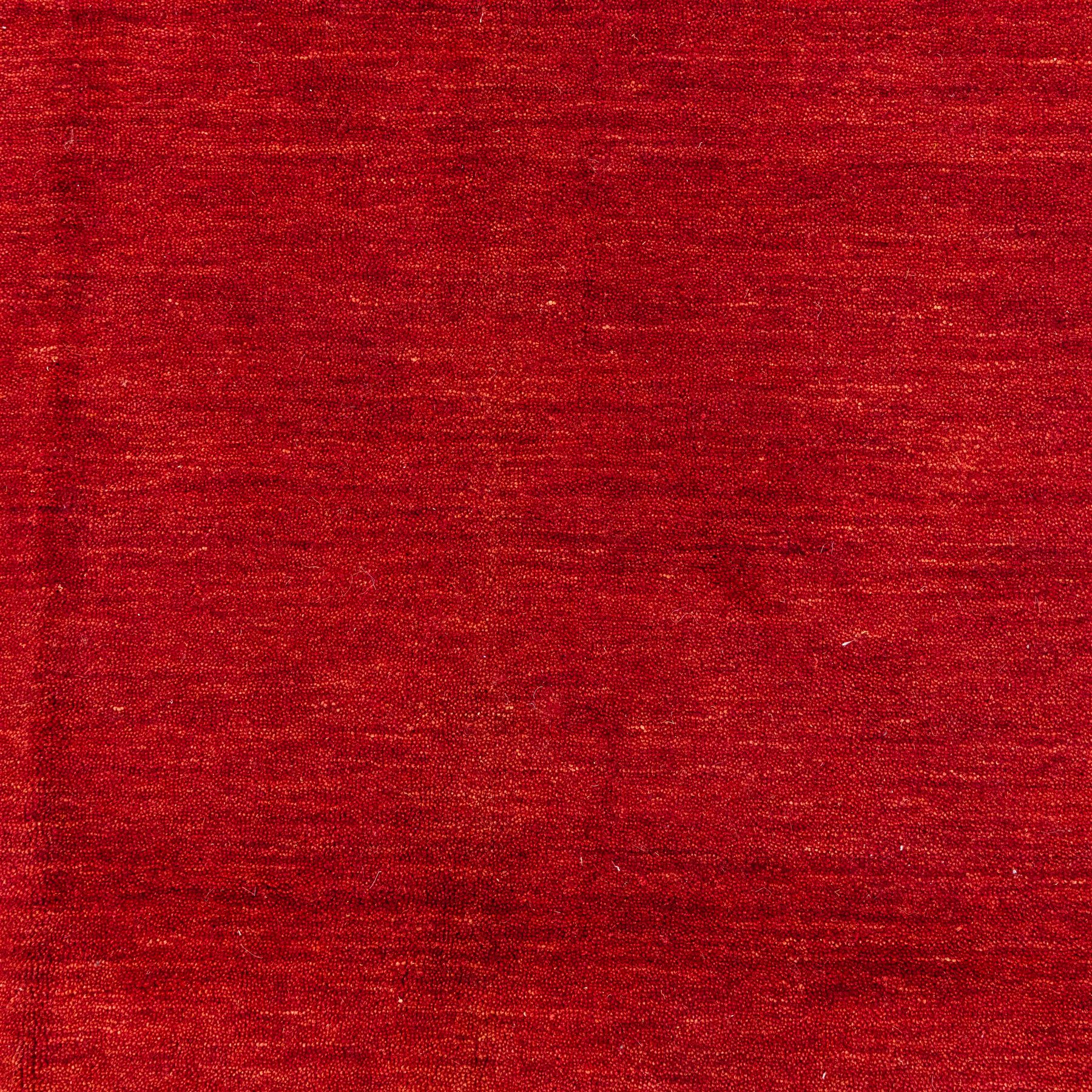 Two contemporary Moroccan Berber hand-woven rugs, deep madder red field of plain design, 199x153cm, other with deep madder red field with a simple lattice of ivory lines forming panels with some tonal variation, 190x146cm 