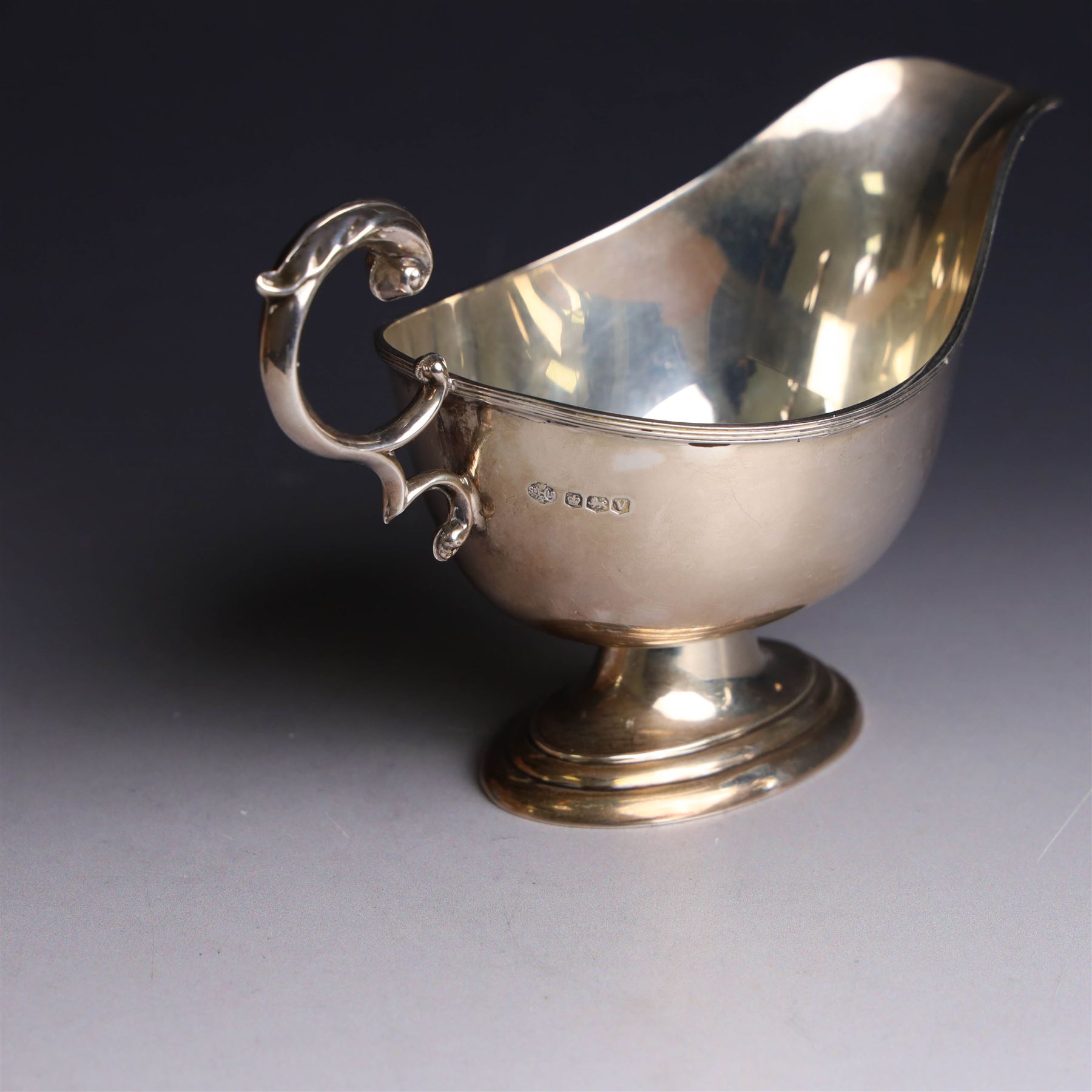 1930s silver sauce boat, of typical form with acanthus capped flying C scroll handle and upon stepped oval foot, hallmarked William Hutton & Sons Ltd, Sheffield 1938, height including handle H10cm