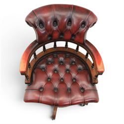 Captains swivel desk chair upholstered in oxblood leather, buttoned back and seat, shaped arm bow raised on turned spindles, five spoke base raised on castors